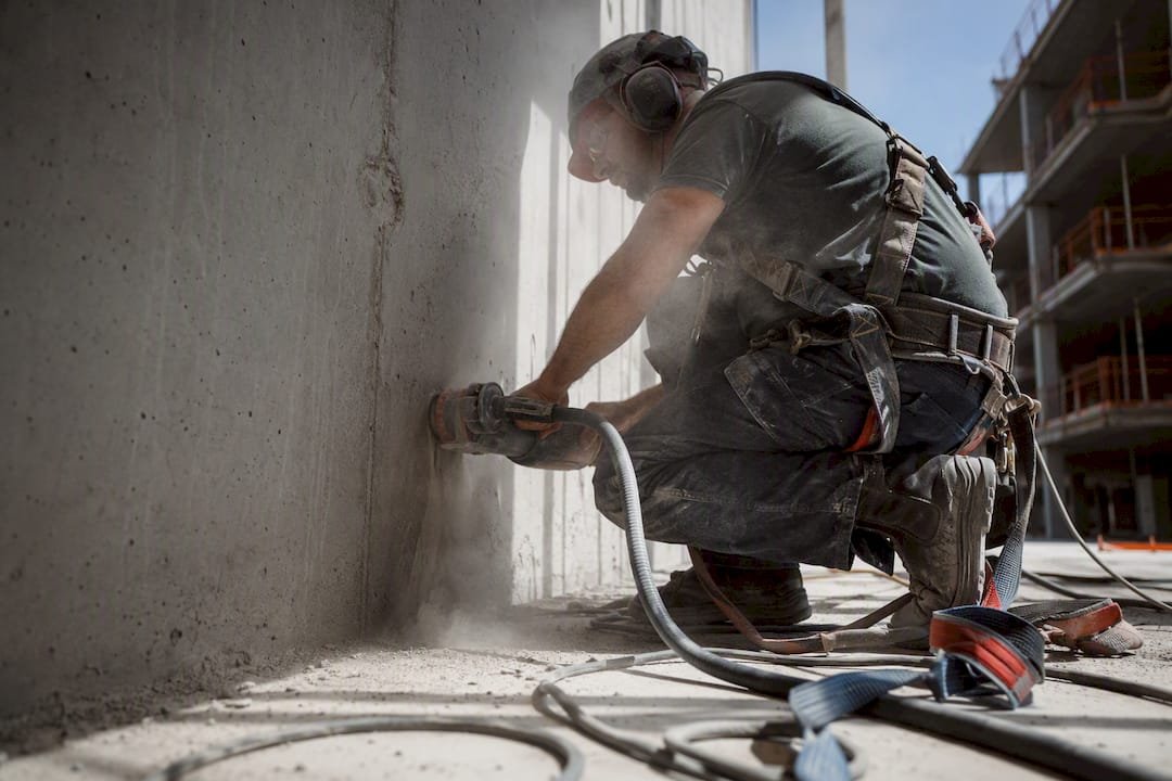 Elektrikas gręžia betoninę sieną